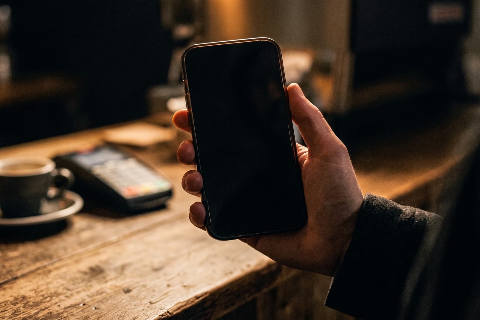 Cartão fidelidade do Bonicard aberto no celular de um cliente, no balcão de uma cafeteria.